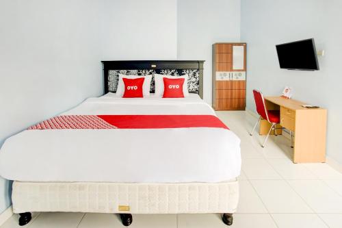 a bedroom with a large bed with red pillows at OYO Life 3982 Azka Homestay Syariah in Bandar Lampung
