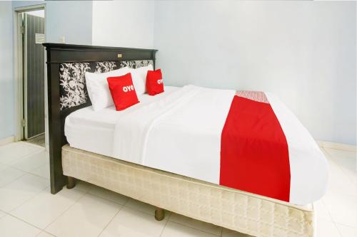 a bedroom with a bed with red pillows on it at OYO Life 3982 Azka Homestay Syariah in Bandar Lampung