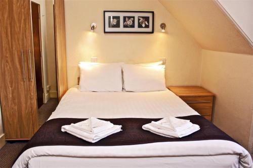 a hotel room with a bed with towels on it at Central Hotel Golders Green in London