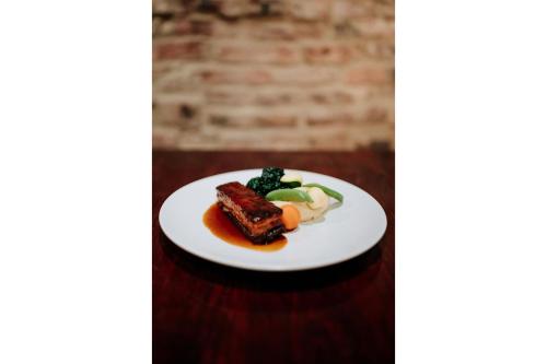 a plate of food with meat and vegetables on a table at OYO The Leven in Stokesley