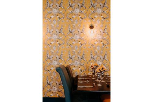 a dining room with a wall covered in ornate wallpaper at OYO The Leven in Stokesley