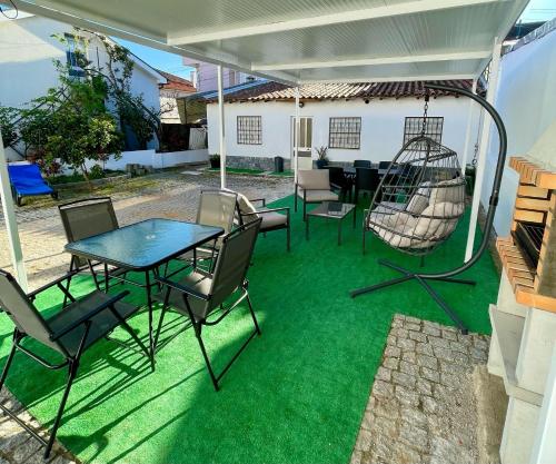 un patio con tavolo, sedie e altalena di Alojamento Local Afonso a Macedo de Cavaleiros