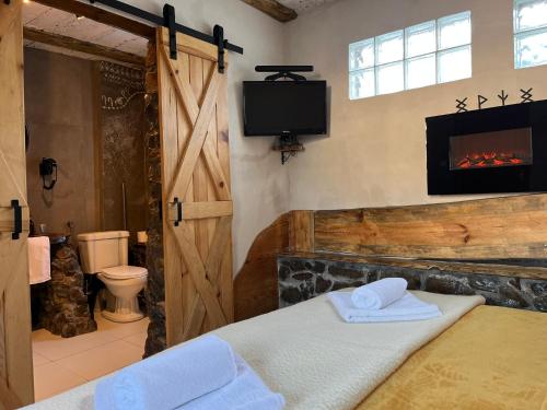 a bathroom with a fireplace and a room with a bed at Wąkop 6 Agroturystyka Eco in Nowa Słupia
