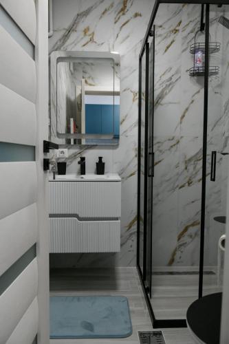 a bathroom with a sink and a mirror at SiaNest in Piatra Neamţ