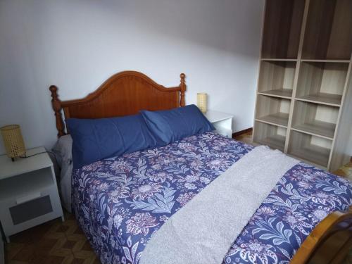 a bedroom with a bed with a blue and purple blanket at A Ribeira in Fene