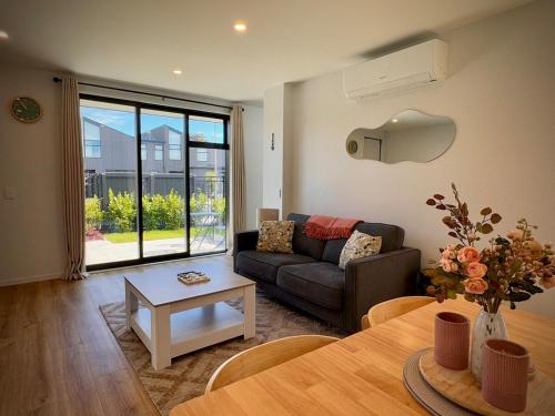 a living room with a couch and a table at Luxury 2Bed2Bath Standalone Home With Parking in Christchurch