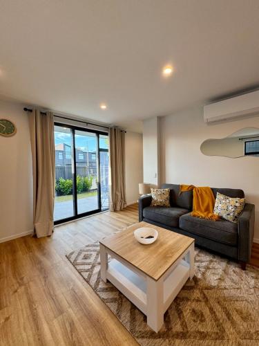 a living room with a couch and a coffee table at Luxury 2Bed2Bath Standalone Home With Parking in Christchurch