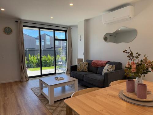 a living room with a couch and a table at Luxury 2Bed2Bath Standalone Home With Parking in Christchurch