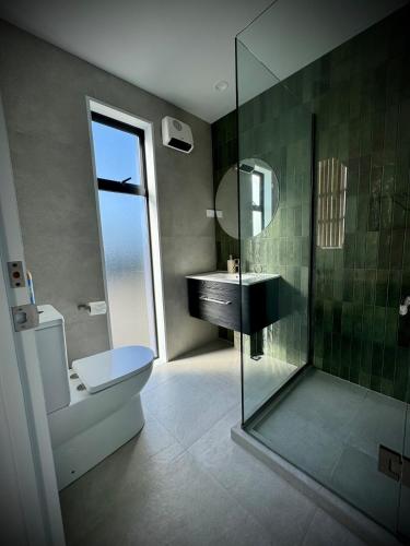 a bathroom with a sink and a glass shower at Luxury 2Bed2Bath Standalone Home With Parking in Christchurch