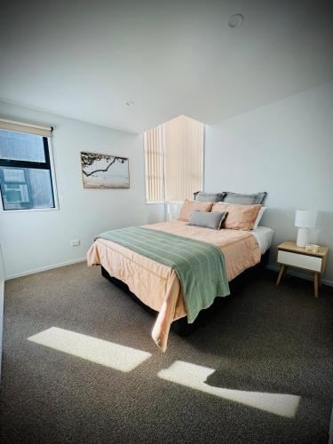 a bedroom with a large bed and a window at Luxury 2Bed2Bath Standalone Home With Parking in Christchurch