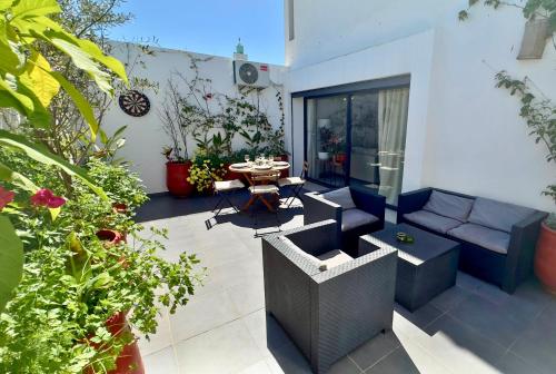 a patio with a couch and a table and some plants at Cozy 2 bedrooms flat at Dar Bouazza in Dar Bouazza