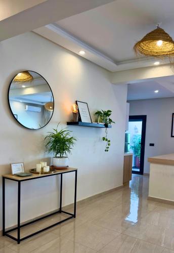 a hallway with a table and a mirror at Cozy 2 bedrooms flat at Dar Bouazza in Dar Bouazza