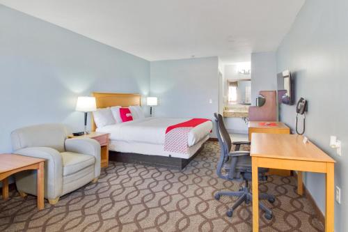 a hotel room with a bed and a desk and chair at OYO Hotel Ingleside TX in Ingleside