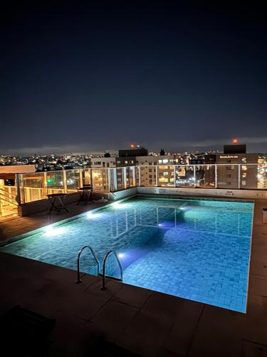 a swimming pool on top of a building at night at Studio, Próximo ao Consulado EUA in Porto Alegre