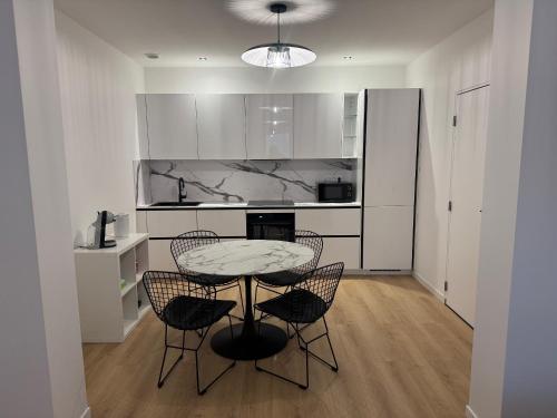 a kitchen with a table and chairs in a room at Appartement I - Haut Standing Proche Luxembourg & Cattenom in Nilvange