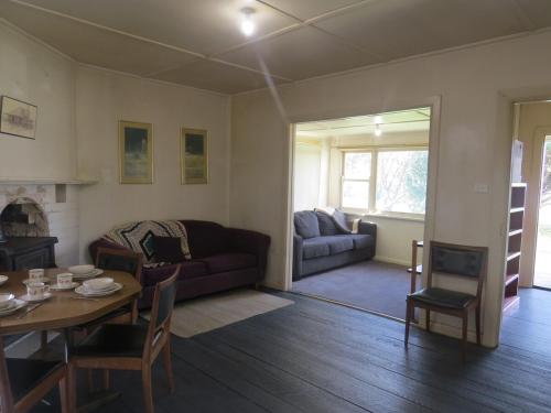 a living room with a table and a couch at Humble family or workers accom in Bombala