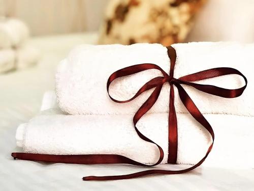 a stack of towels with a bow on top at Hotel Park in Batumi