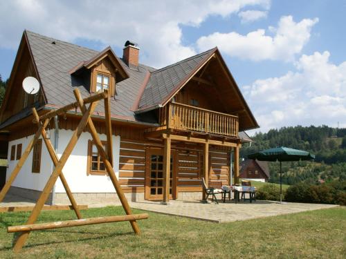Cozy Holiday Home in Stupna with Private Garden في Stupná: كابينة خشب كبيرة أمامها ملعب