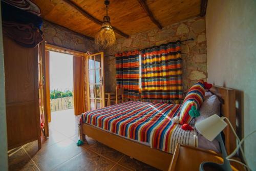 a bedroom with a bed with a stone wall at MesklilHouse in Asilah
