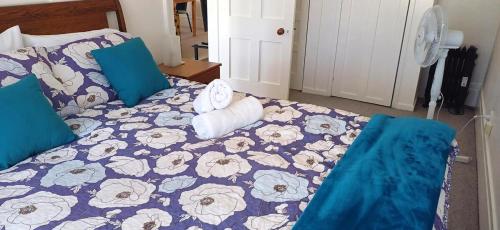 a bedroom with a bed with a blue comforter at Charming Getaway Relax and Unwind in Nelson