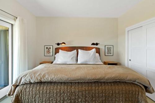 a bedroom with a large bed with two pillows at Breathtaking Views of the Pacific Ocean Rooftop Balcony Gourmet Kitchen and Hot Tub overlooking Golf Course in Bodega Bay