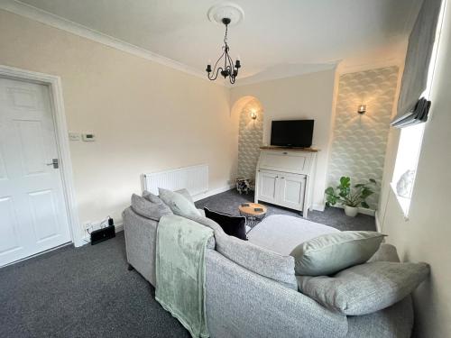 a living room with a couch and a tv at Lollipop Cottage in Skipton