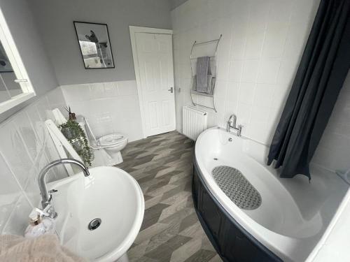 a bathroom with a tub and a sink and a toilet at Lollipop Cottage in Skipton