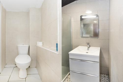 a white bathroom with a toilet and a sink at Old Oak Tree Inn in Hounslow