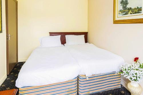 a bedroom with two beds with white sheets at Old Oak Tree Inn in Hounslow