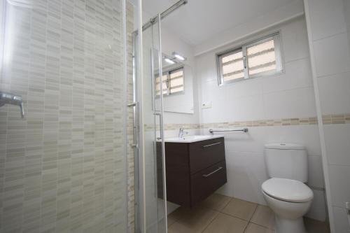 un bagno con wc e doccia in vetro di CABALLOS 2D - ESTUDIO - Fincas Arena a Benidorm