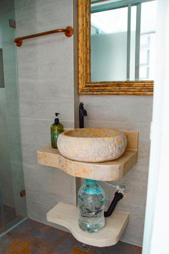 a bathroom sink with a mirror on a wooden shelf at Laguna Beach, Brisa Marina playa Frances in Coveñas