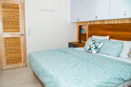 a bedroom with a bed with a blue comforter at Laguna Beach, Brisa Marina playa Frances in Coveñas