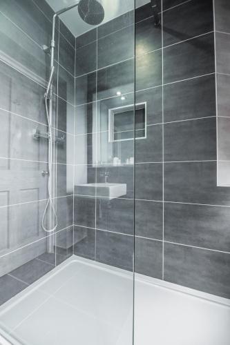 a bathroom with a shower with a glass door at St Valery Boutique Bed + Breakfast in Alnmouth