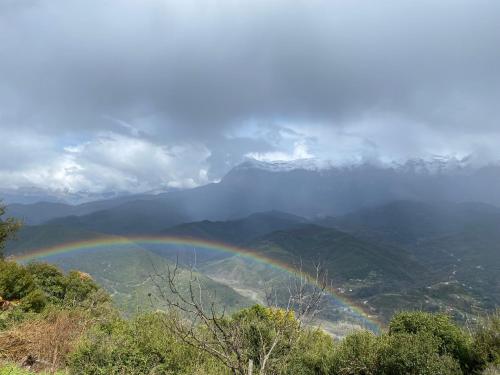 a rainbow over a valley with a mountain at ToVouno in Plaka