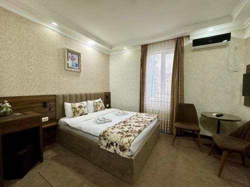 a hotel room with a bed and a desk and a window at Hotel Park in Batumi