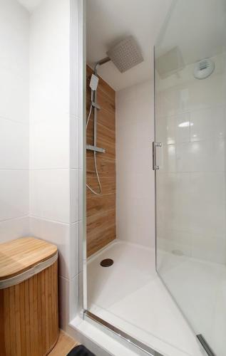 une douche avec une porte vitrée dans une salle de bain dans l'établissement T2 NEUF - 8min de Lyon - Parking privé -Terrasse, à Irigny