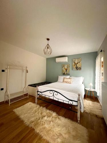 a bedroom with a white bed and a rug at ToVouno in Plaka