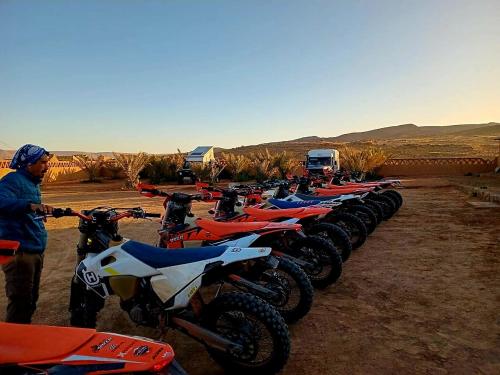 a row of motorcycles parked in the desert at Auberge Dar Lajdoud in Tafraoute Sidi Ali