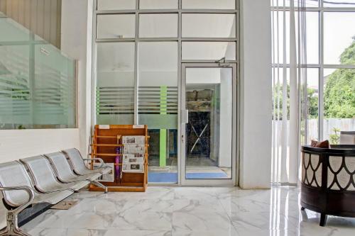 a living room with a chair and a large window at Hotel O Permata Inn in Banjarmasin