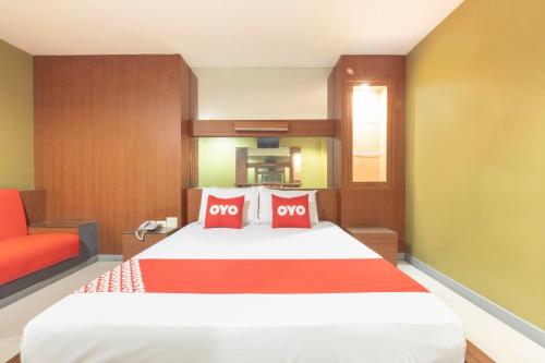a bedroom with a large bed with two red pillows at OYO 75382 Chonburi Hotel in Chon Buri