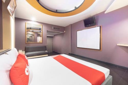 a bedroom with a large white bed with a red blanket at OYO 75382 Chonburi Hotel in Chon Buri