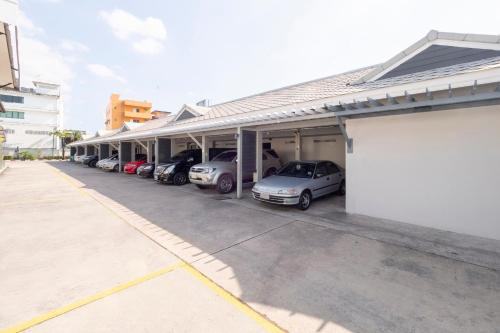 a row of cars parked in a parking lot at OYO 75382 Chonburi Hotel in Chon Buri