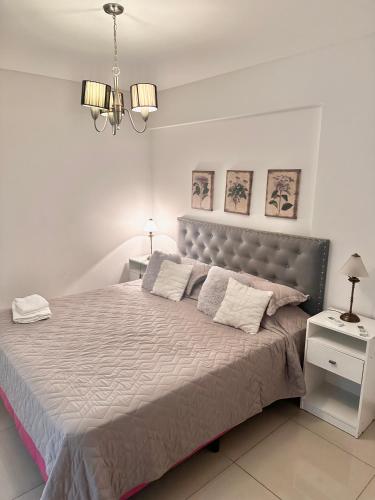 a bedroom with a large bed with a gray headboard at Foster Palermo Heras Suites in Buenos Aires
