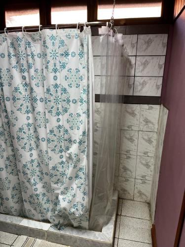 a shower with a shower curtain in a bathroom at Hostal Puerta del Sol Molina in Molina