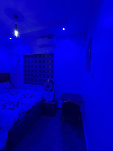 a blue room with a bed and a table at Cee&Tee ABK 1BEDROOM -247Electricity - Solar Inverter AC in bedroom in Abeokuta