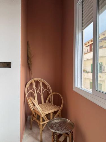 a chair sitting in a corner next to a window at Cozy apartment Heart of medina Tetuan in Tetouan