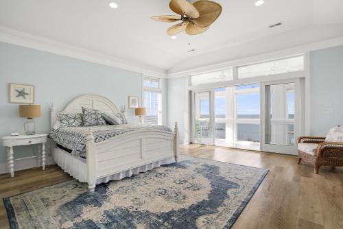 a bedroom with a bed and a ceiling fan at The Blue Pearl - Luxurious beachfront living with community pool! in Cape Charles