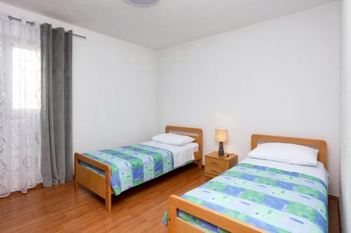 una camera da letto con due letti e una finestra di Apartments with a parking space Stupin Celine, Rogoznica - 23812 a Rogoznica (Rogosnizza)