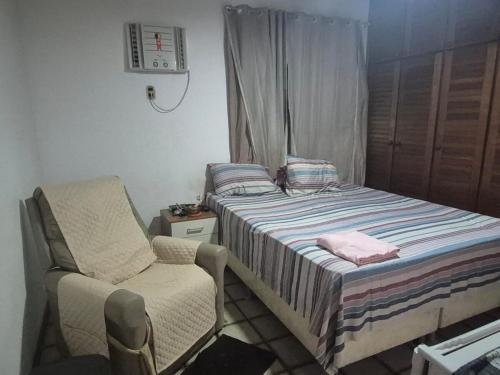 a small bedroom with a bed and a chair at Apartamento São Brás COP 30 in Belém