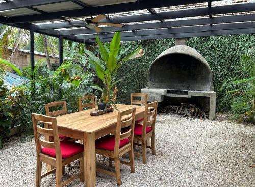 a wooden table and chairs with a pizza oven at Pachamama Tropical Garden Lodge in Carmen